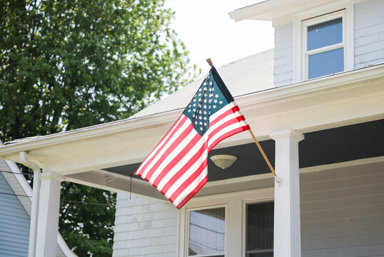 us flag proudly displayed in front of an american house symbolizes patriotism, national identity, an