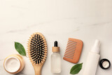 Flat lay composition with wooden hair brush and comb on white marble table, space for text