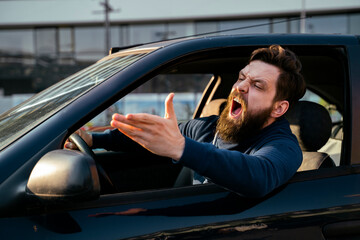 Bearded young man road raging , yelling from the car closeup shot