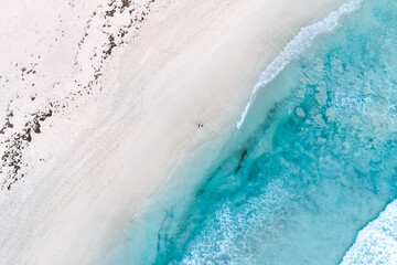 Wall Mural - Aerial view of summer seascape beautiful waves, blue sea water on sunny day. Top view from drone. Sea aerial view, amazing tropical nature background. Beautiful bright sea waves splashing on the beach