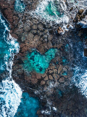 Wall Mural - Aerial view of beautiful love heart shaped reef in tropical blue ocean sea waters with shallow waves. Vibrant bright sunny day in summer wallpaper. Seascape background. Coastal wallpaper. Love island