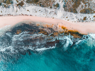 Wall Mural - Aerial view of pink sandy beach with waves. Sunny day in summer with transparent tropical blue water. Summer seascape beautiful waves, blue sea water on a sunny day. Top view from drone. Sea aerial