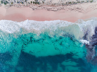  Aerial view of pink sandy beach with waves. Sunny day in summer with transparent tropical blue water. Summer seascape beautiful waves, blue sea water on a sunny day. Top view from drone. Sea aerial