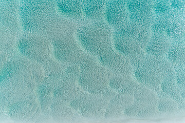 aerial view of beautiful tropical turquoise ocean sea waters with shallow waves. vibrant bright sunn