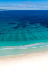 Wall Mural - Summer seascape beautiful waves on the sunny white sand beach, blue sea water in sunny day. Top view from drone. Sea aerial view, amazing tropical nature background. Beautiful bright sea waves splash