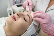 © RomanR - beautician applies or removes moisturizer from a client's face
