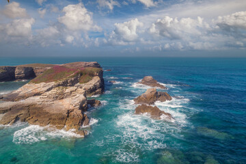 Wall Mural - Seascape on a sunny day. Rocks in the ocean. Beach Praia Dos Castros, Ribadeo, Galicia, Spain