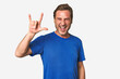 © Asier - A middle-aged man isolated showing a horns gesture as a revolution concept.