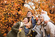 © KOTO - Family playing in autumn leaves in park