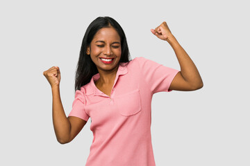 Wall Mural - Young Indian woman cut out isolated on white background raising fist after a victory, winner concept.