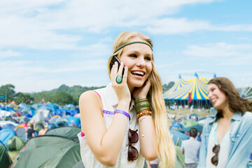 Wall Mural - Woman talking on cell phone outside tents at music festival