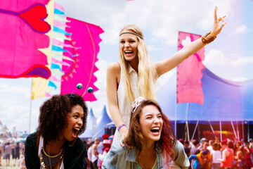 Wall Mural - Woman piggybacking enthusiastic friend at music festival