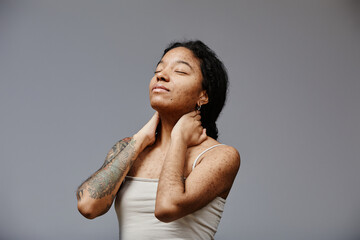 Minimal portrait of black young woman with real skin texture posing confidently with eyes closed, copy space