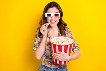 Photo of funky overjoyed person arm hold big pop corn bucket watch 3d glasses movie isolated on yellow color background