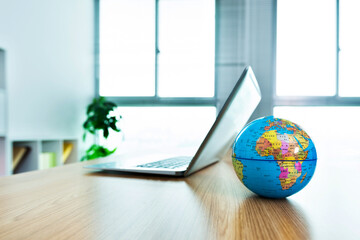 Wall Mural - Office desk with laptop and globe