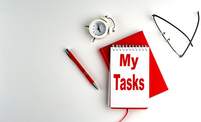 MY TASKS text on notebook , red pen and notebook, business concept, white background