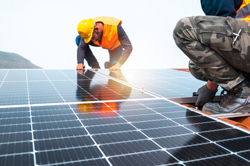 workers assemble energy system with solar panel for electricity and hot water