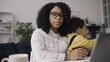 © Synthex - Portrait of African American businesswoman balancing maternity and work, sitting with little son on her lap at workplace