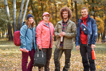 Wall Mural - Holidays with friends. Group of young people walking together in the park.