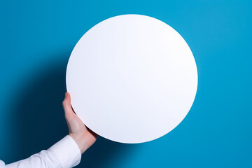 Poster - circle empty white mockup in hand on blue background generative ai