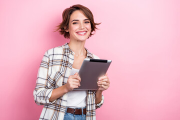 Photo of pretty sweet woman dressed plaid shirt communicating modern gadget empty space isolated pink color background