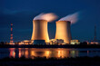 Nuclear power plant after sunset, river in foreground. Dusk landscape with big chimneys. power plant at night. night lights of nuclear power station. environmental protection air pollution concept