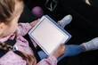 © Aleksandr - Mock up of little girl using digital tablet on car seat. Trip with family