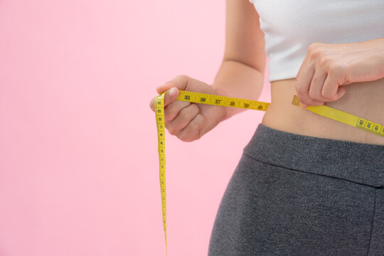 Diet and dieting. Beauty slim female body use tape measure. Woman in exercise clothes achieves weight loss goal for healthy life, crazy about thinness, thin waist, nutritionist.