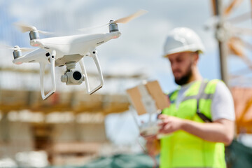 Wall Mural - drone operated by safety engineering inspector. construction worker piloting drone on building site