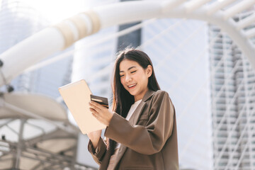 Wall Mural - Happy smile young woman using creadit card and digital tablet for shopping online payment