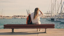 A Tourist Girl Rests On A Bench In A Yacht Club.