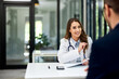 © bnenin - A smiling female doctor talking with a male patient about his health condition.