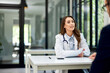 © bnenin - A pretty female doctor talking with a male patient in the examination room.