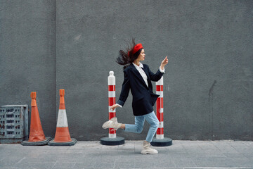 Fashion woman running down the street in front of the city tourist in stylish clothes with red lips and red beret, travel, cinematic color, retro vintage style, late to work.