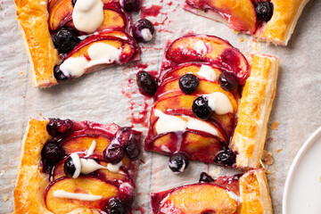 Wall Mural - Delicious nectarine and blueberry puff pastry pie with vanilla glaze