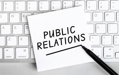 Poster - White paper with text public relations lying on the keyboard