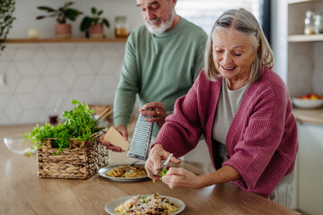 Wall Mural - Senior couple cooking together in their kitchen.