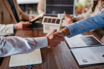 Wall Mural - Close up of businesmans shaking hands in office.