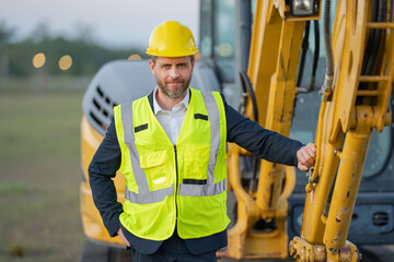 Civil engineer worker at a construction site. Engineer man in front of house background. Confident engineer worker at modern home building construction. Hispanic civil engineer in helmet.