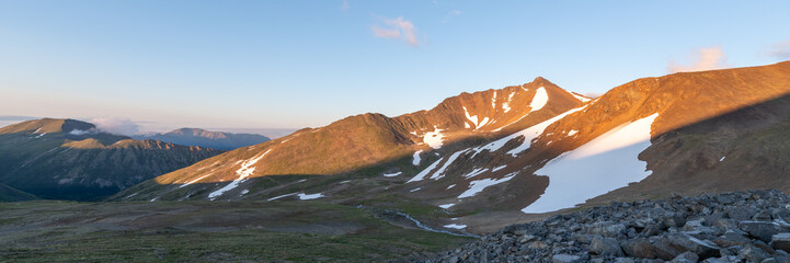 Sunset panoramic views over back country area near Paddy Peak on the Alaska Canada border during summer time with bright blue sky, vast, wilderness area. 
