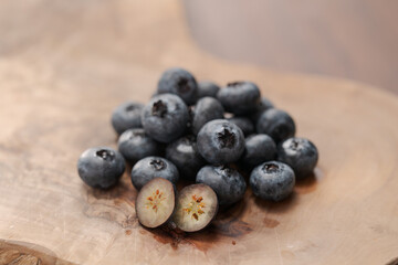 Wall Mural - Fresh blueberries on wood board one berry is cut in halves