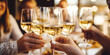 © Jasmina - Close up of group of friends toasting with glasses of white wine at restaurant