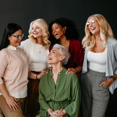 Poster - Multi-ethnic group of beautiful mature women bonding and smiling against black background