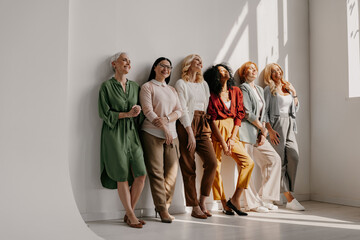 Poster - Multi-ethnic group of mature women bonding and smiling while leaning on the wall together