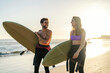 © Dusan Petkovic - A happy surfer couple with surfboards on the beach.