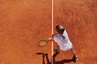 Top view of a professional female tennis player serves the tennis ball on the court with precision and power