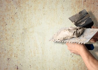 Sticker - worker hand with steal trowel plastering cement on wall