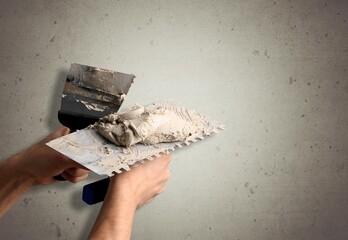 Sticker - worker hand with steal trowel plastering cement on wall