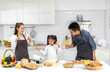 © Art_Photo - Portrait of enjoy happy love asian family father and mother with little asian girl daughter child play and having fun cooking food together with baking cookie and cake ingredient in kitchen
