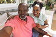 © wavebreak3 - Portrait of smiling senior african american couple making video call in sunny living room